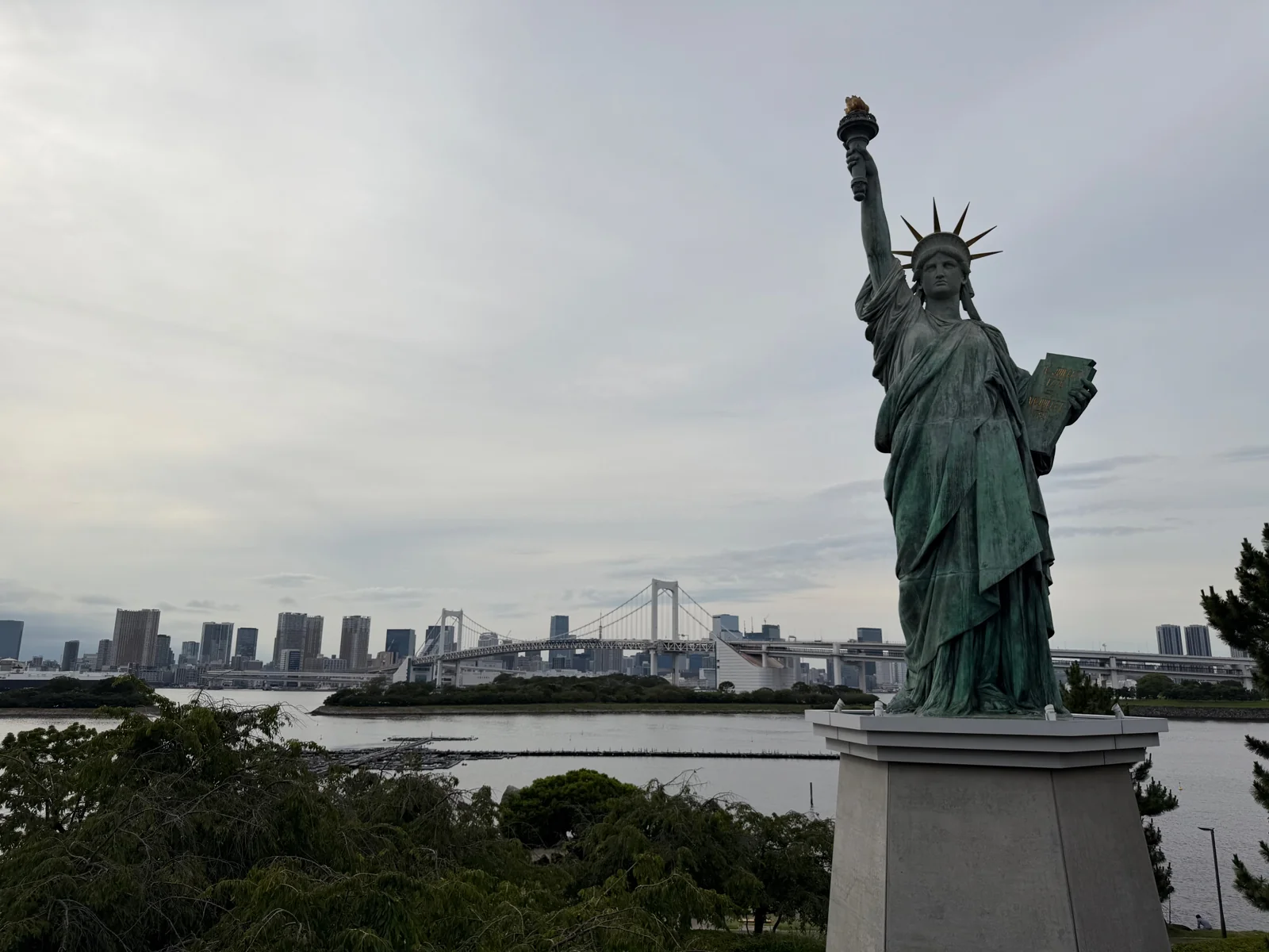 Odaiba’s Statue of Liberty with Rainbow Bridge and the Tokyo skyline behind it.