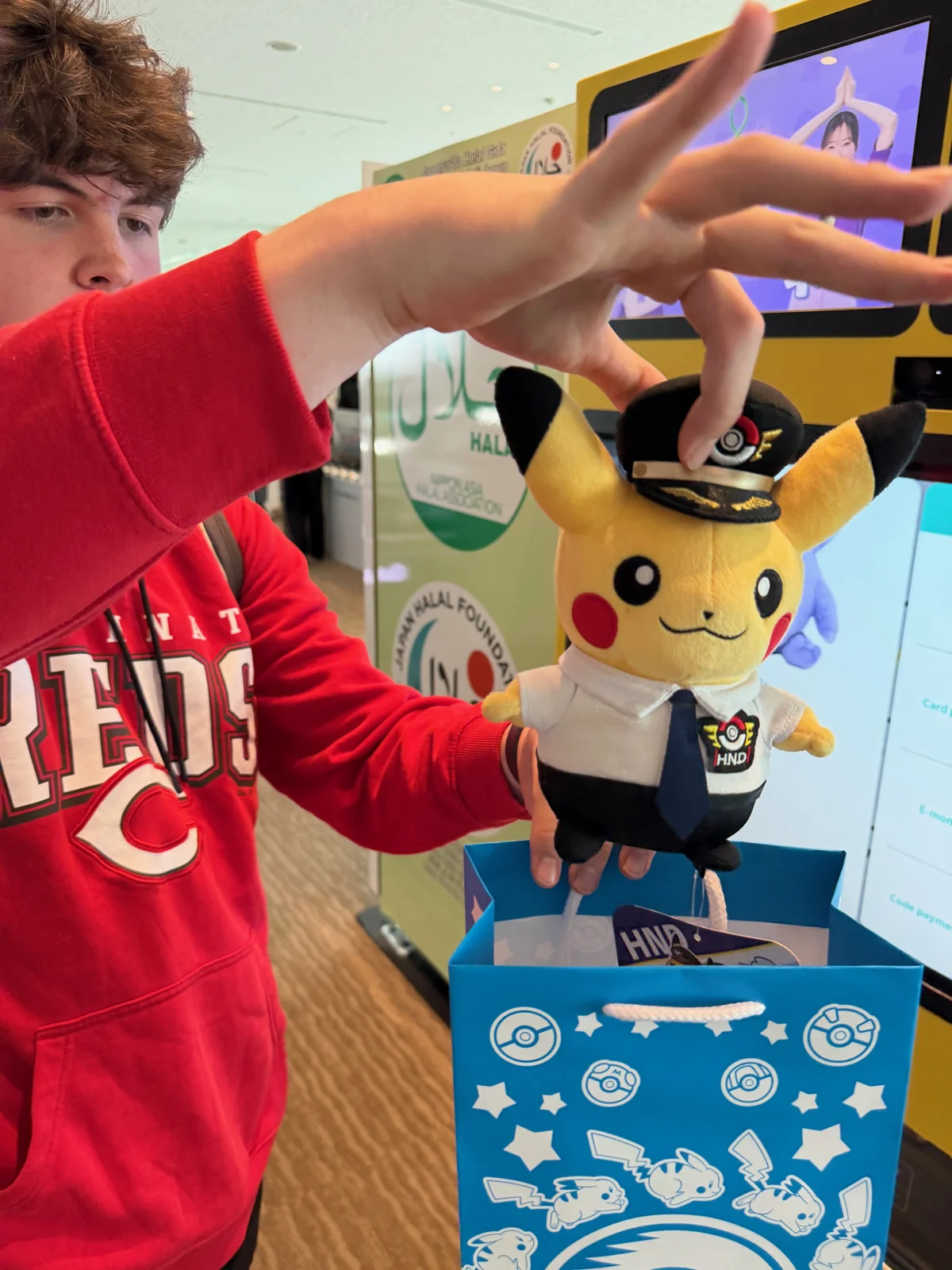 Wesley beside a Pikachu display at Haneda Airport.