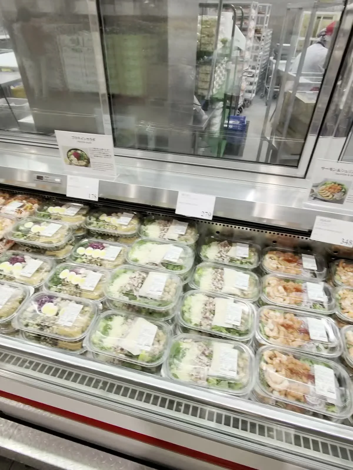 Trays of prepared salads and meals in a refrigerated display at Costco Makuhari.