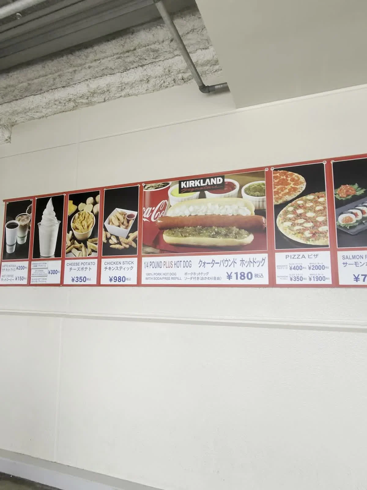 Costco Makuhari food court menu showing a hot dog and drink for 180 yen, pizza, and other snacks.
