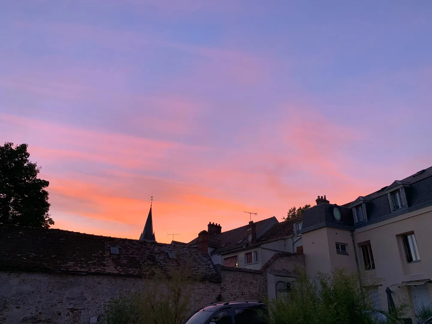Pink sunset above village rooftops