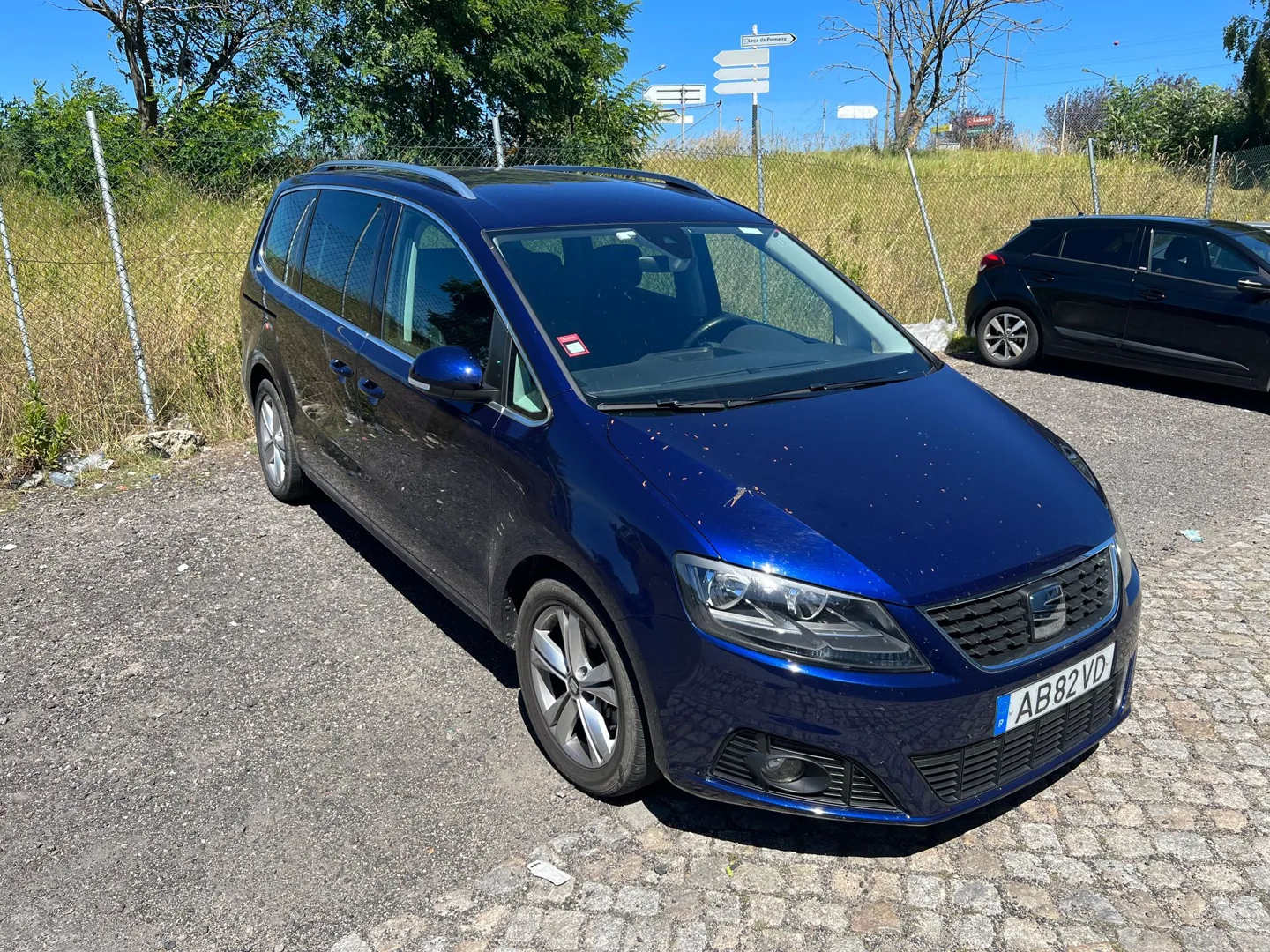 Blue van parked beside a country road