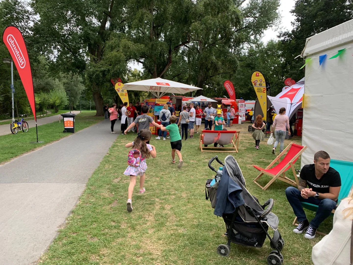 Family walking past lakeside festival stalls