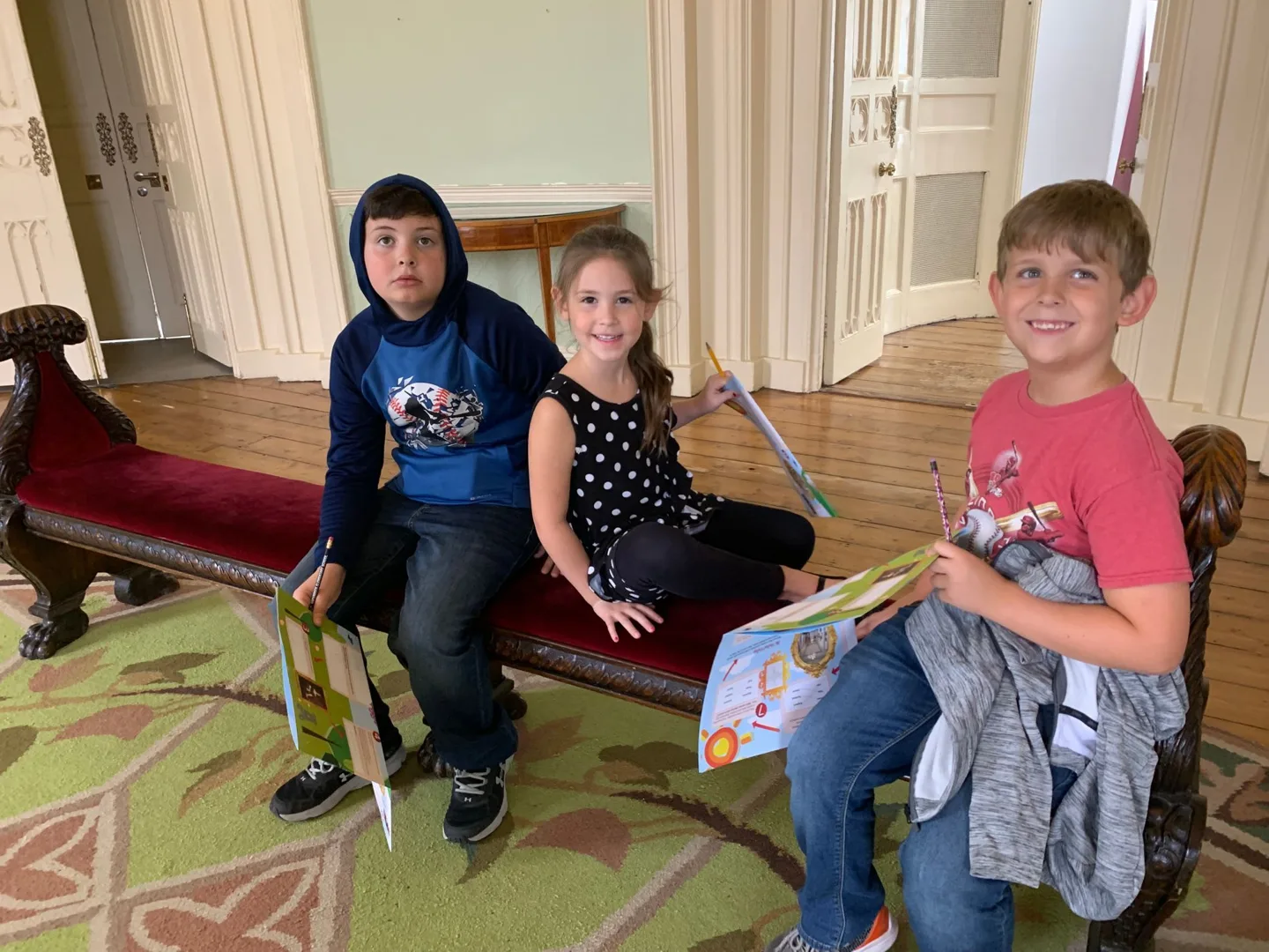 Children gathered around a toy harp indoors