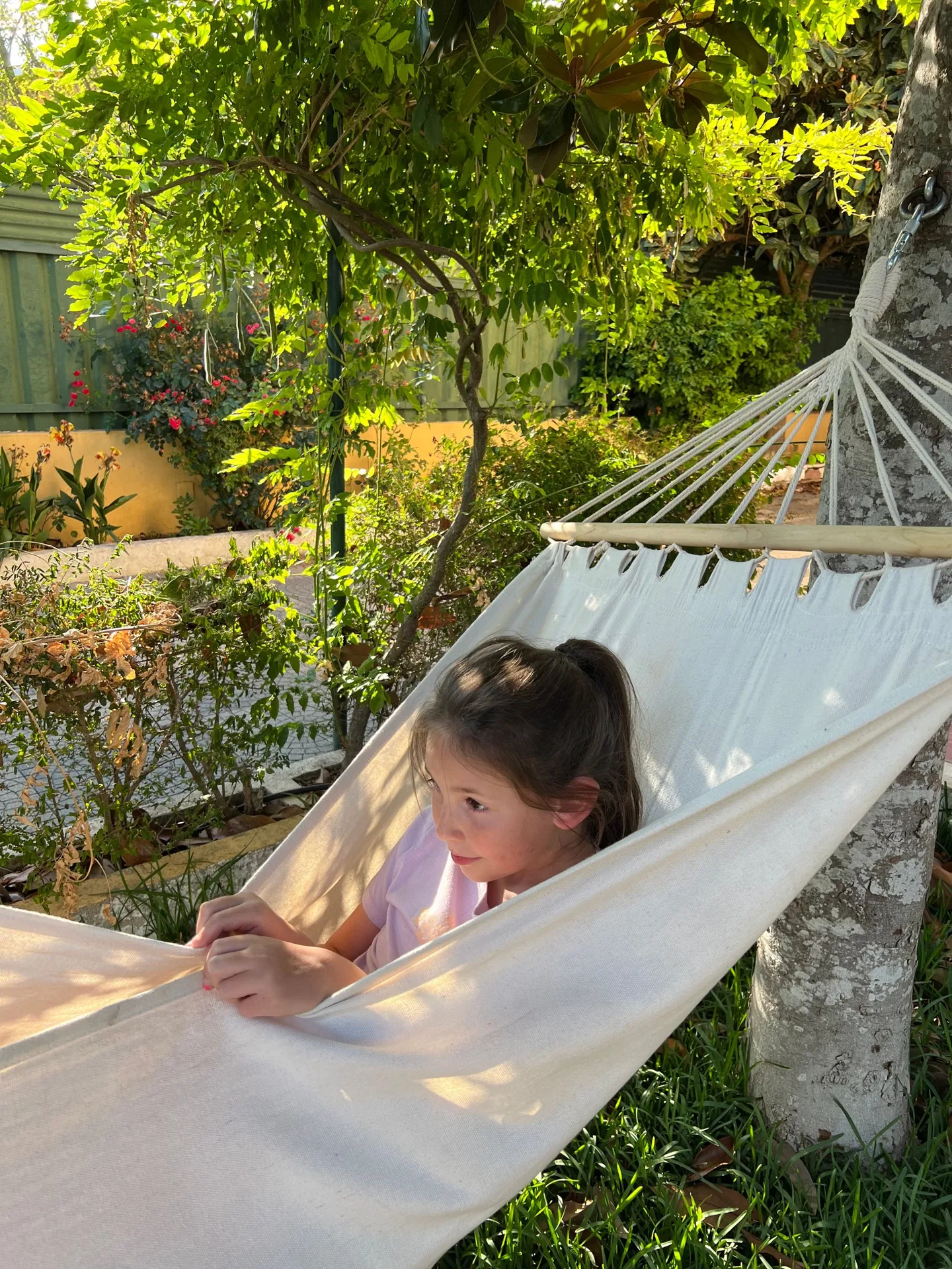 Child resting in a hammock in the garden