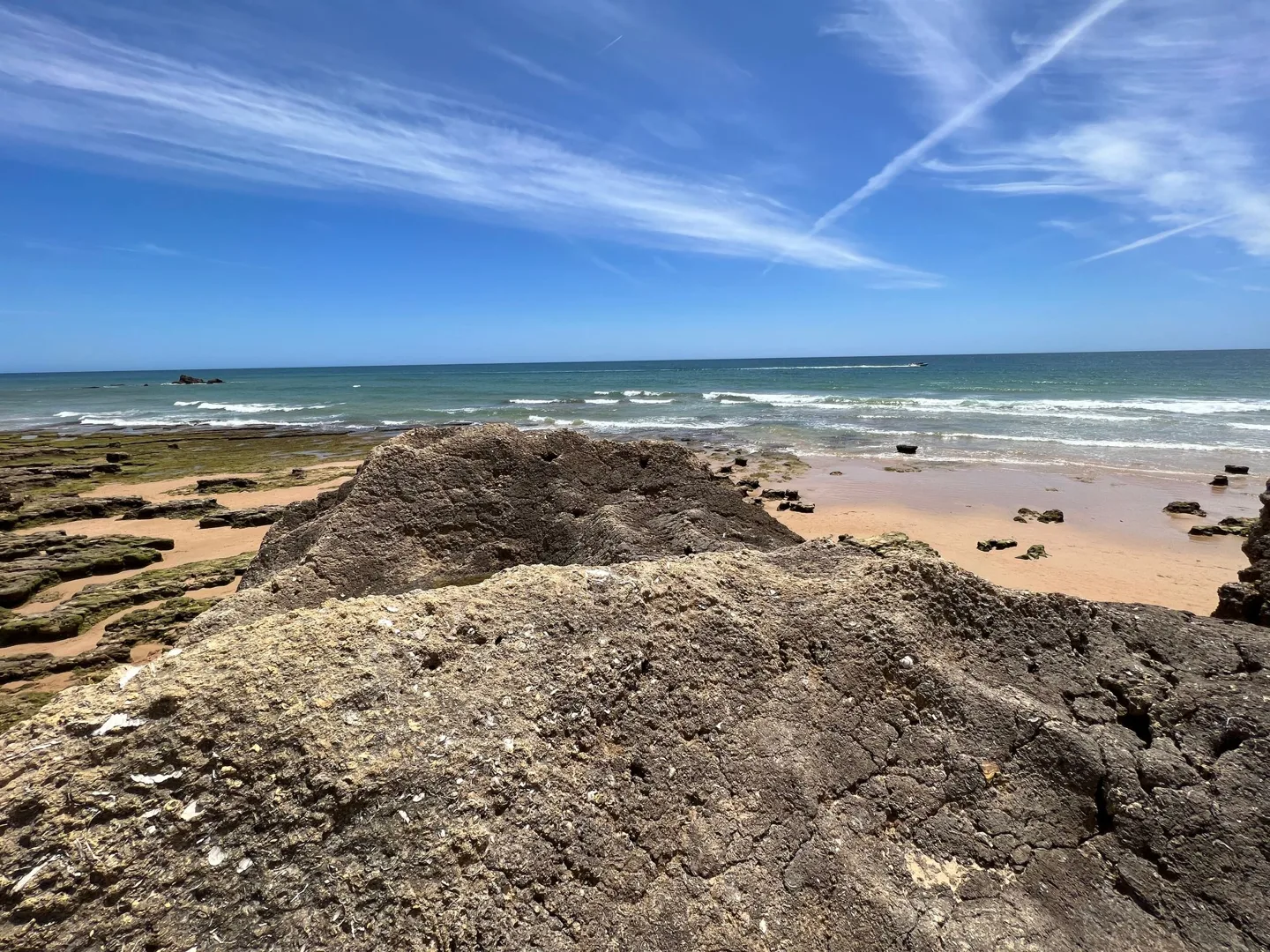 Rocky shoreline beside a sandy beach