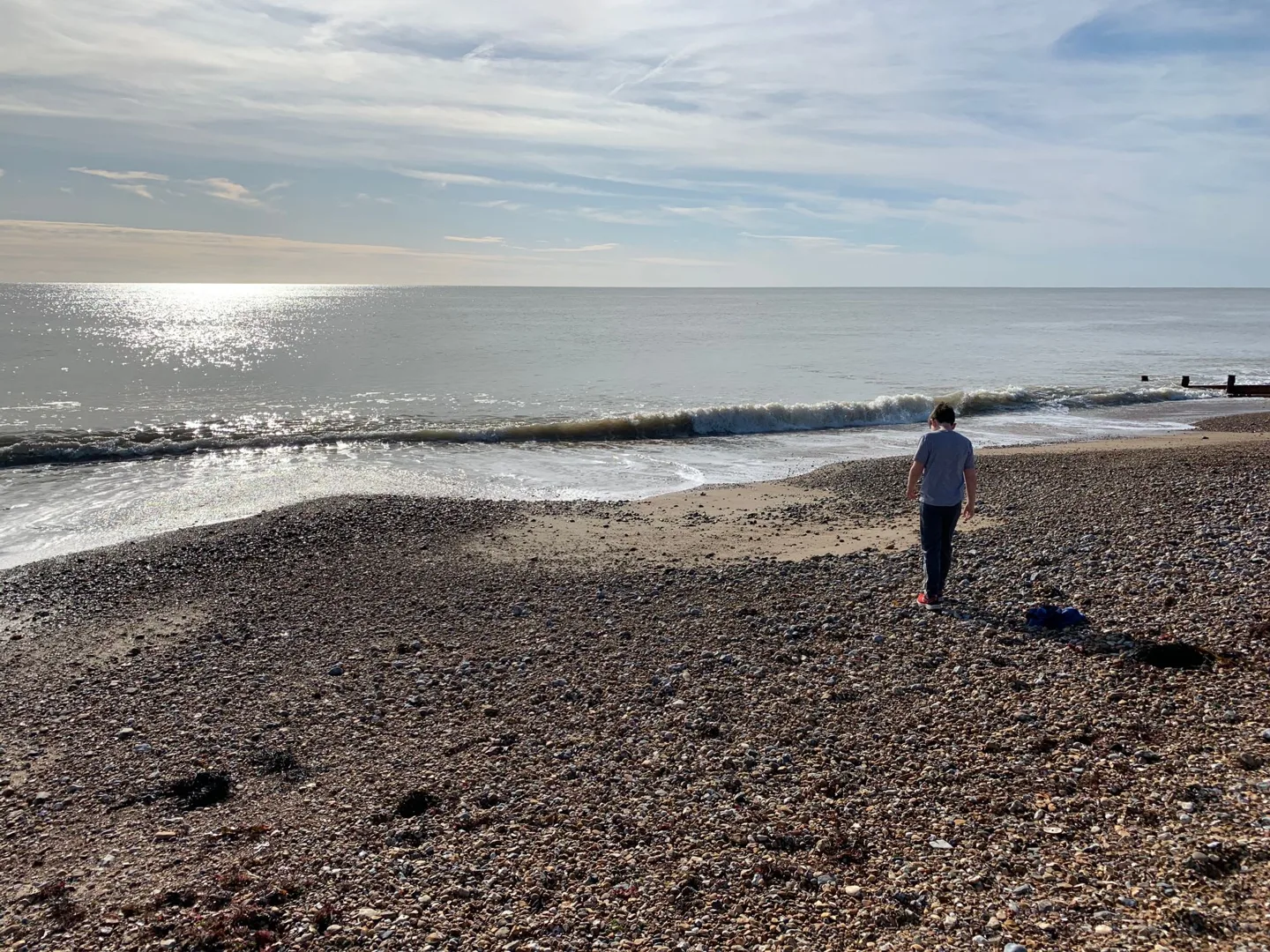 Child on a pebble beach beside the sea