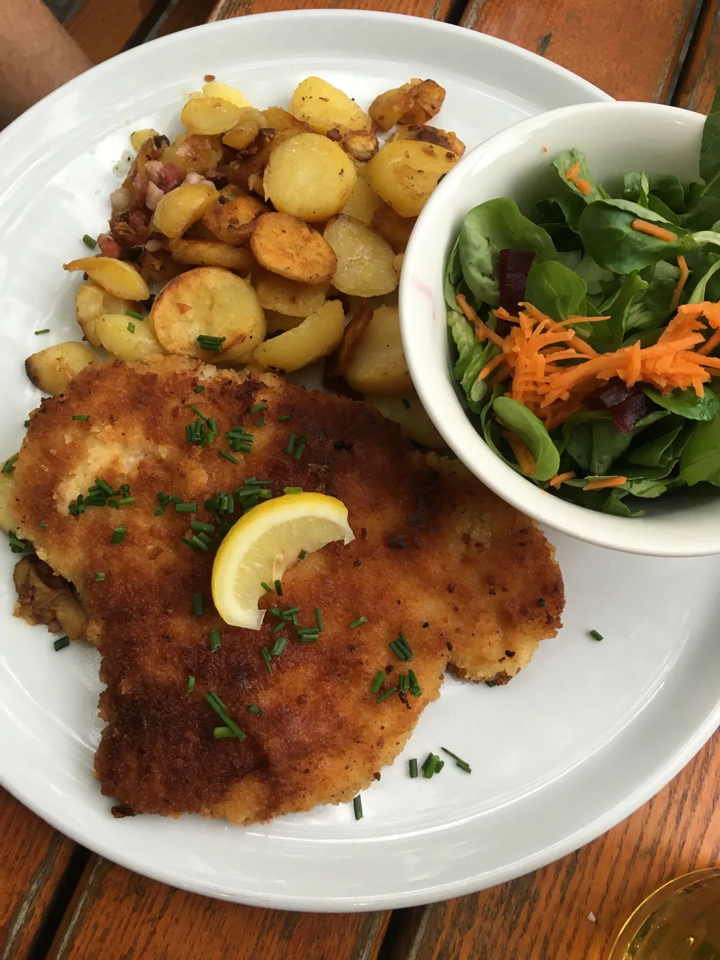 Breaded cutlet with potatoes, lemon, and salad
