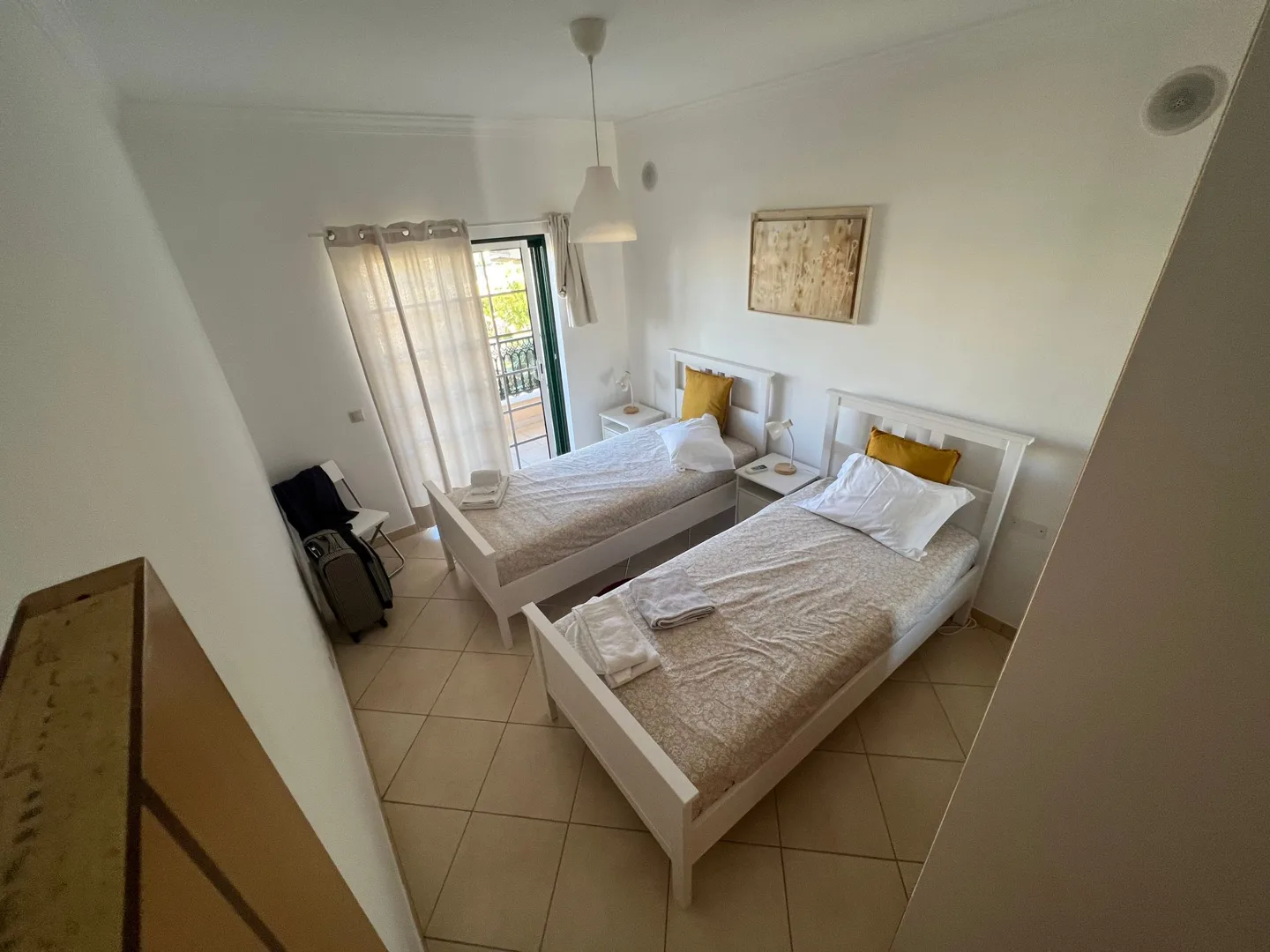 Bedroom with white bedding and a balcony door