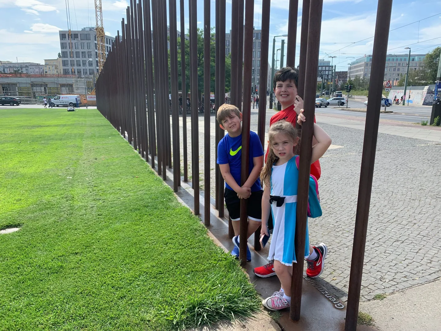 Children beside tall metal bars at the memorial