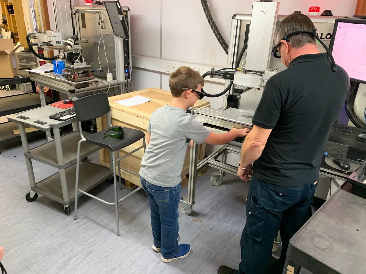 Child working beside an adult at a workshop bench