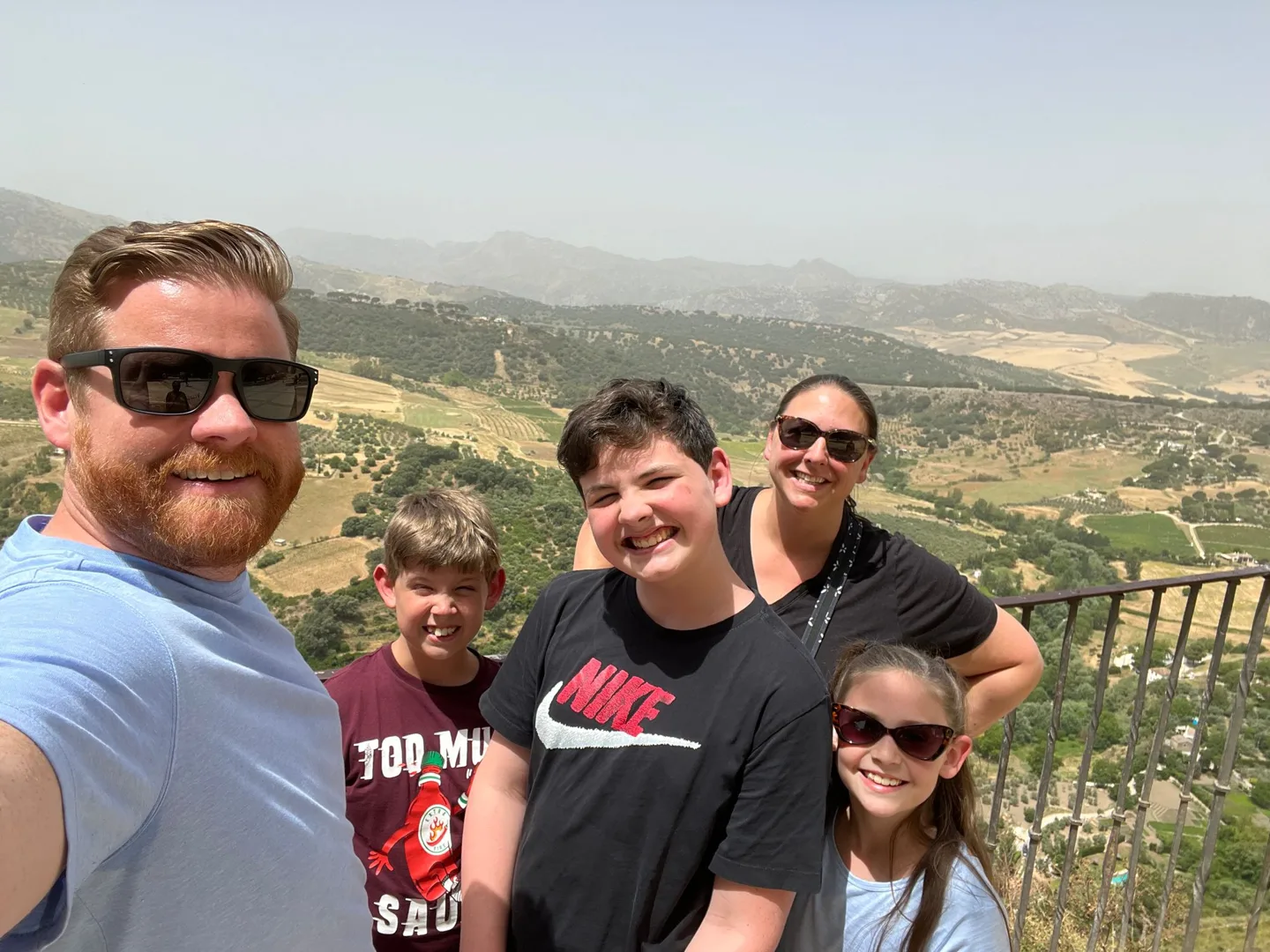 Family posing above a mountain landscape