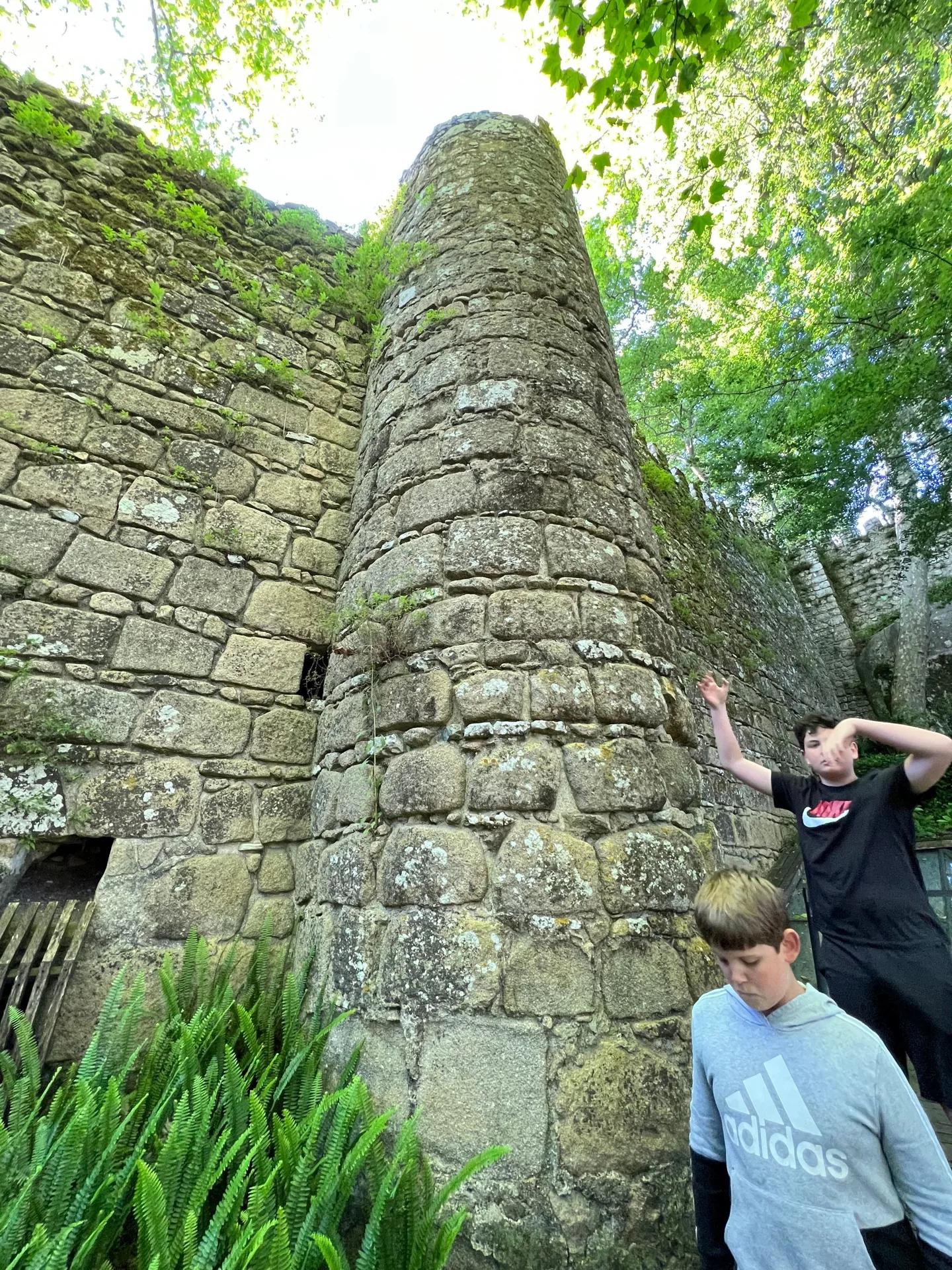 Children beside a mossy stone tower
