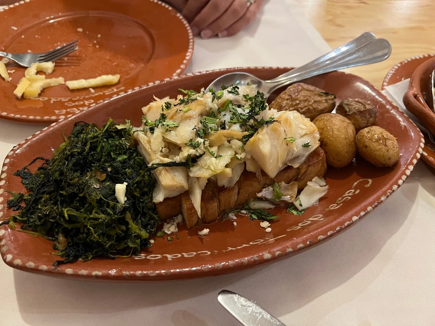 Fish and potatoes served on a terracotta platter