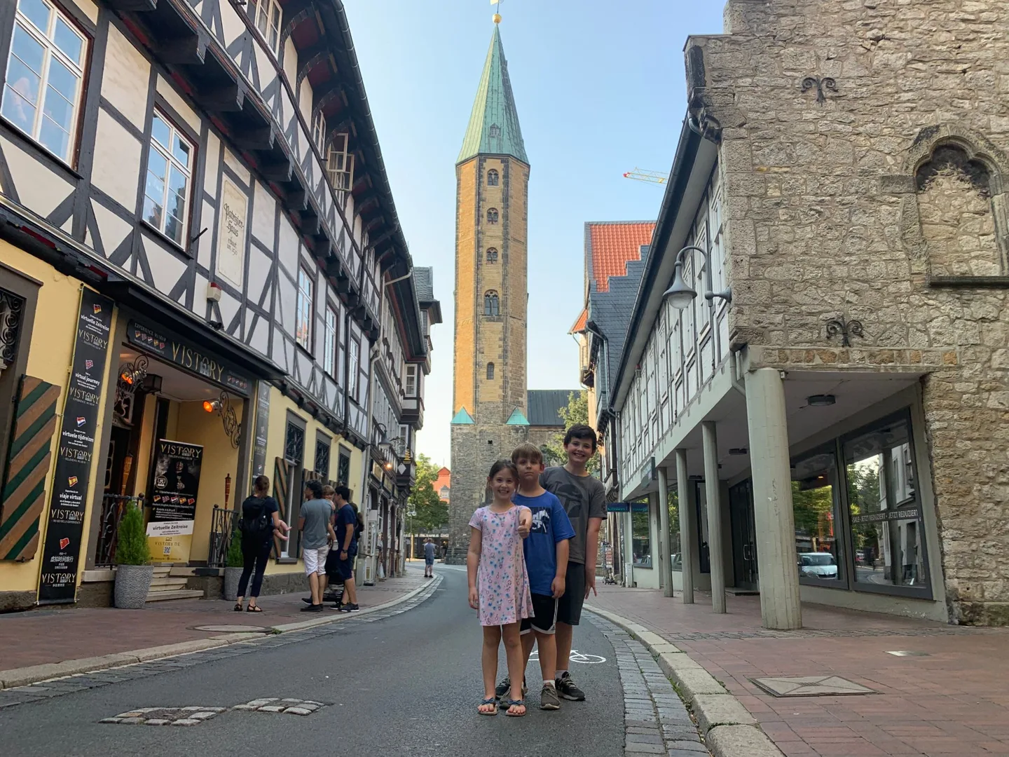 Children on a cobbled street near a church tower