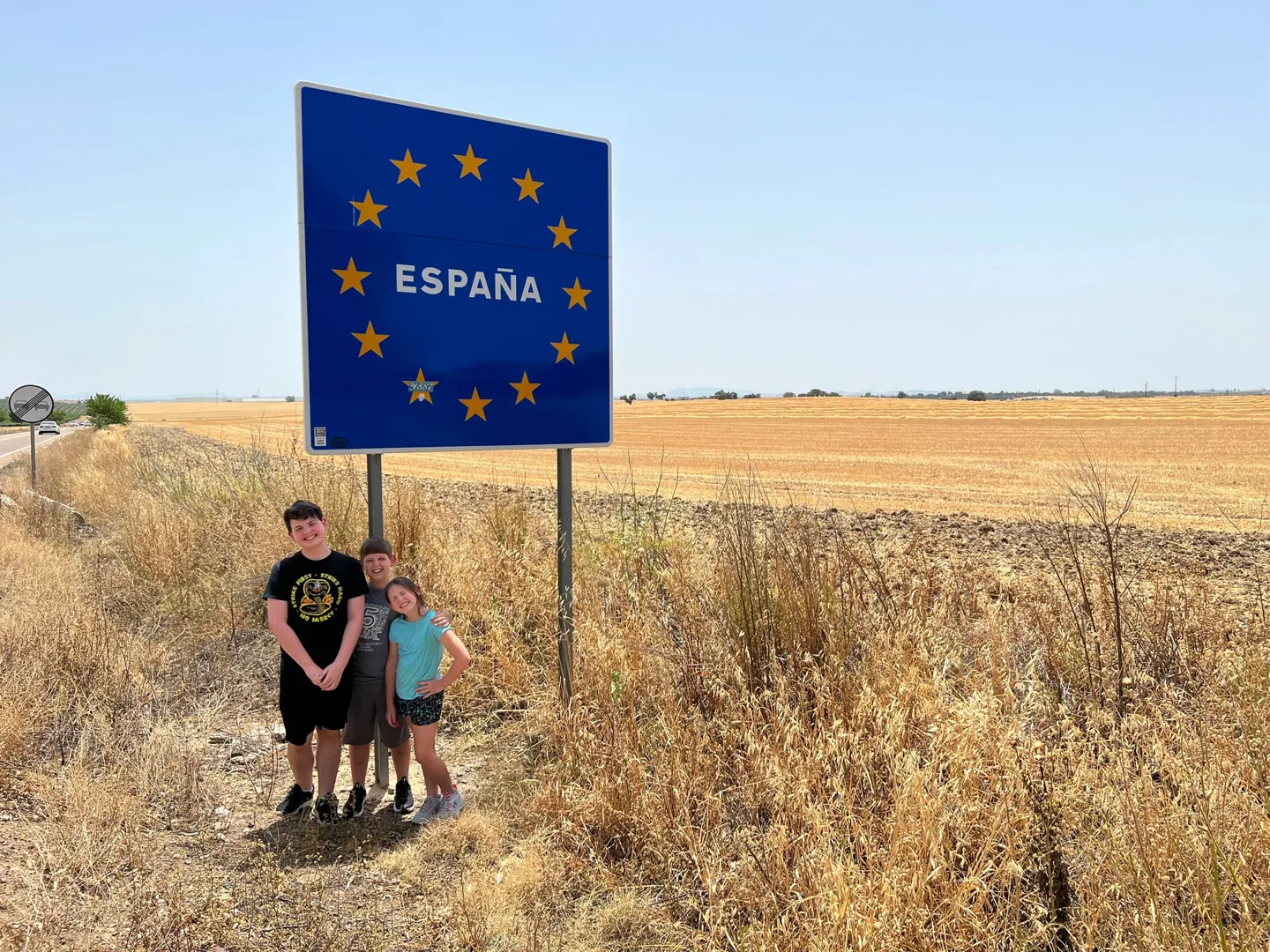Children beneath the España border sign