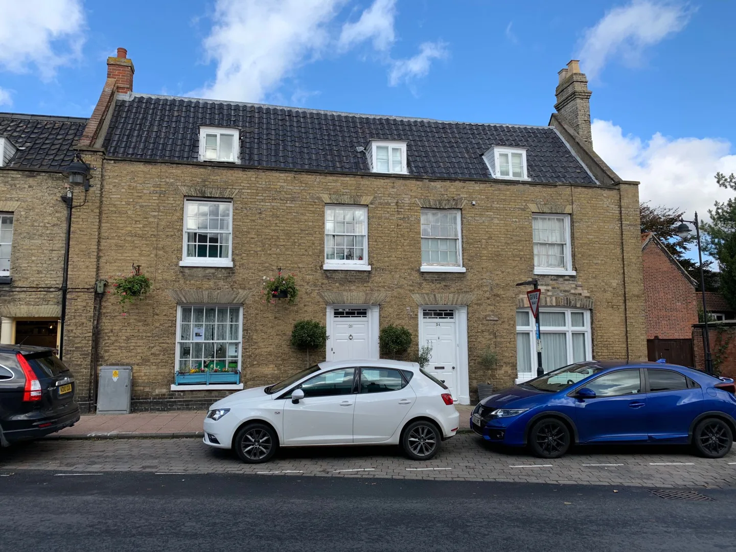 Historic brick house with parked cars