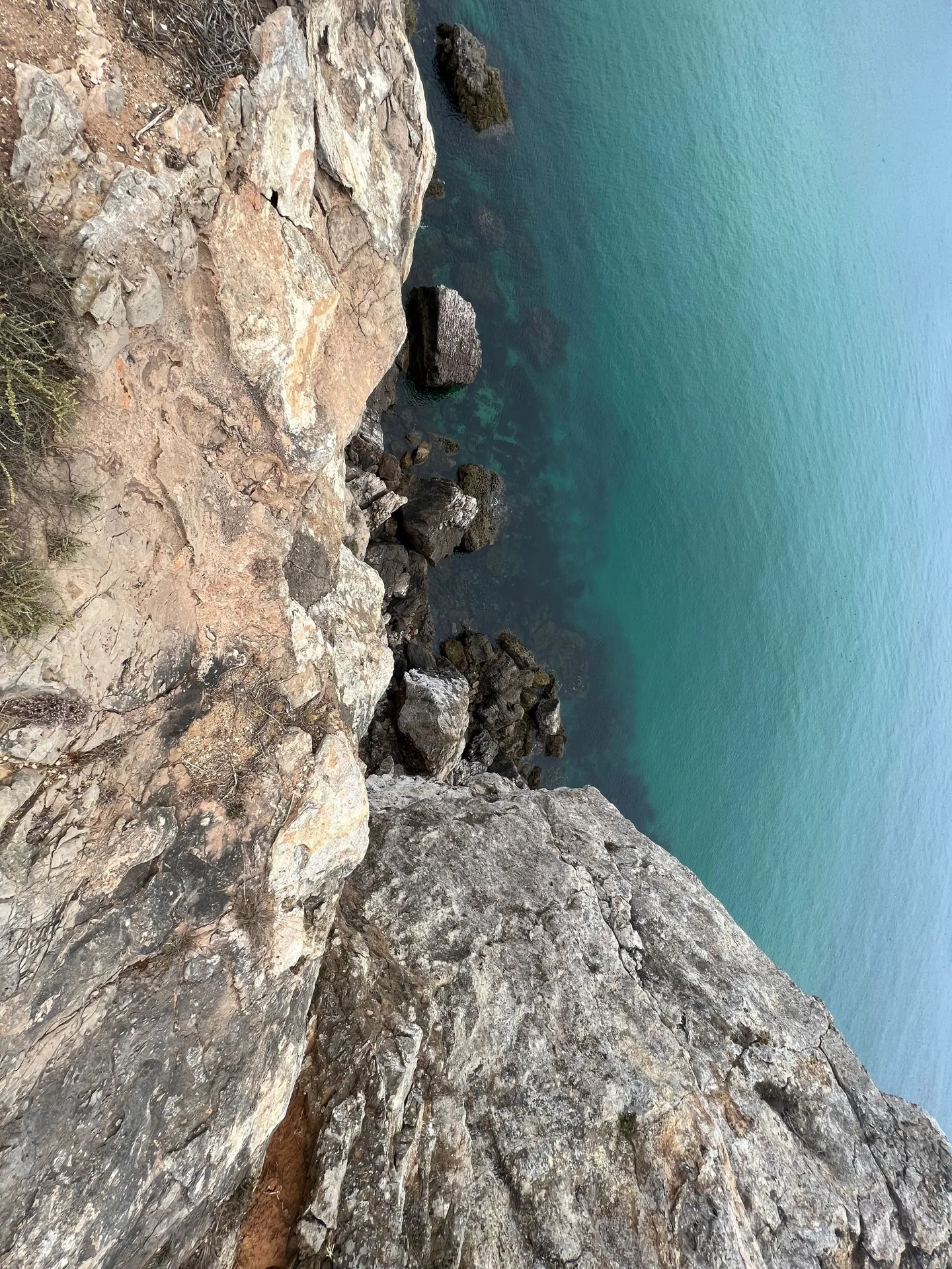 Steep cliff dropping into turquoise water