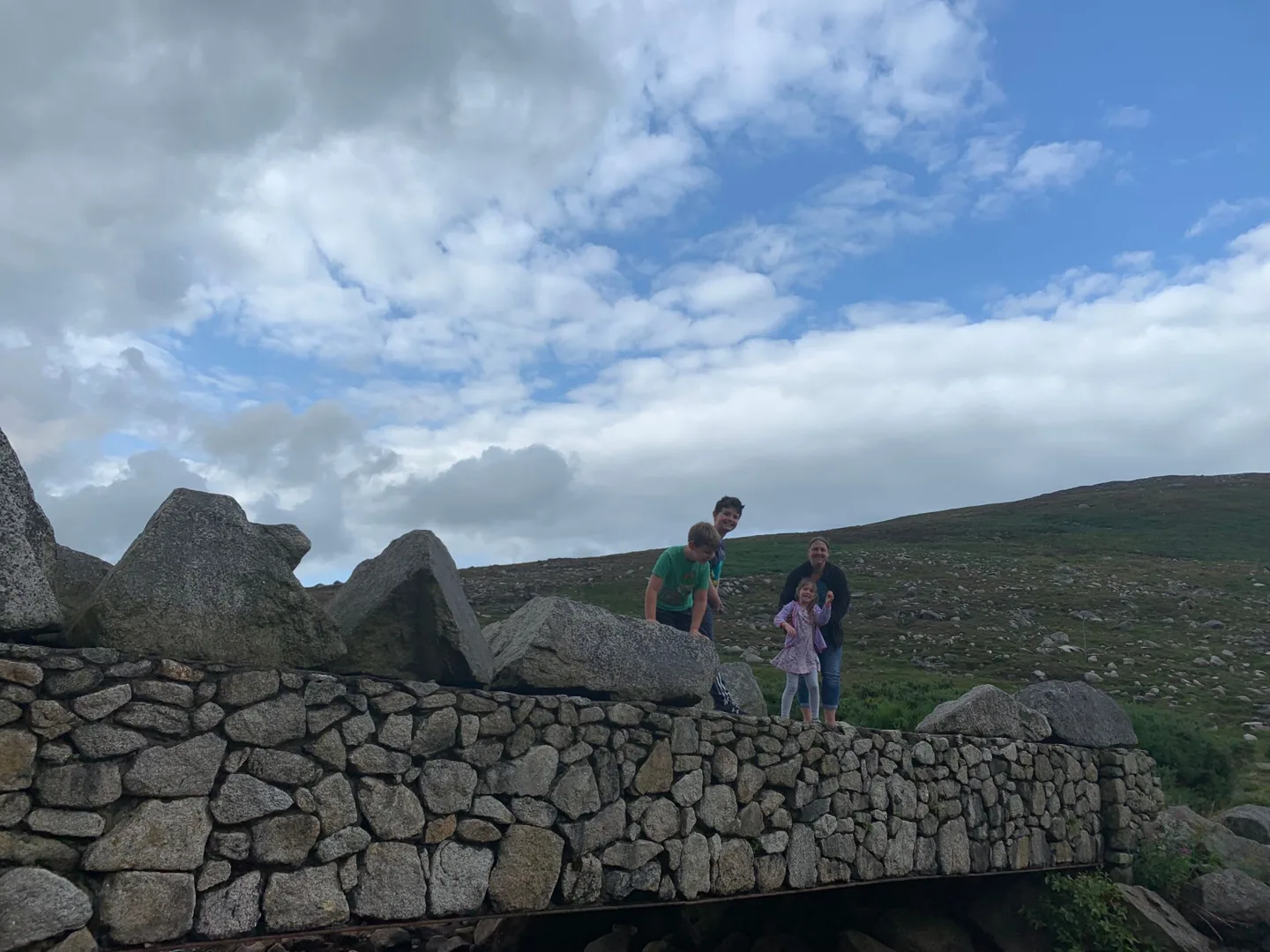 Children beside a dry-stone wall in the hills
