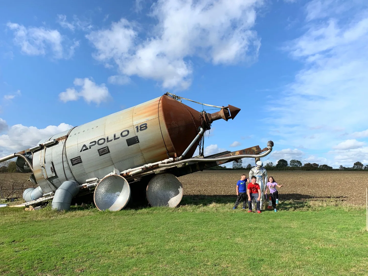 Family beside an old aircraft displayed on grass