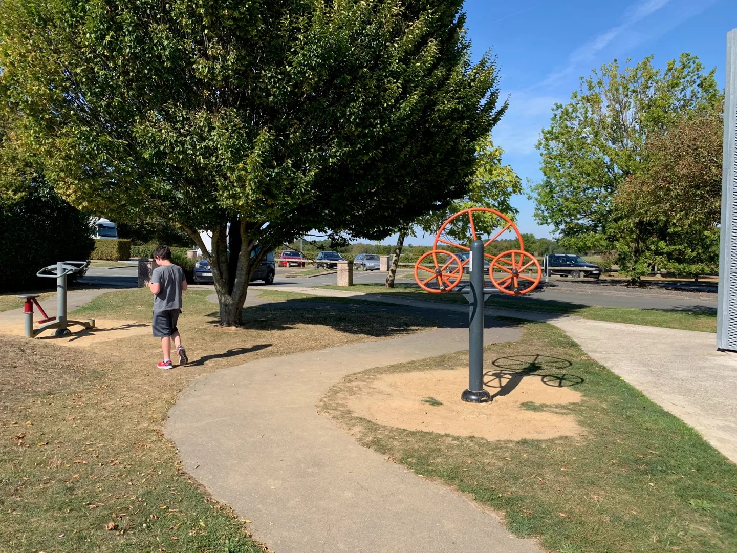 Family walking past a shaded playground