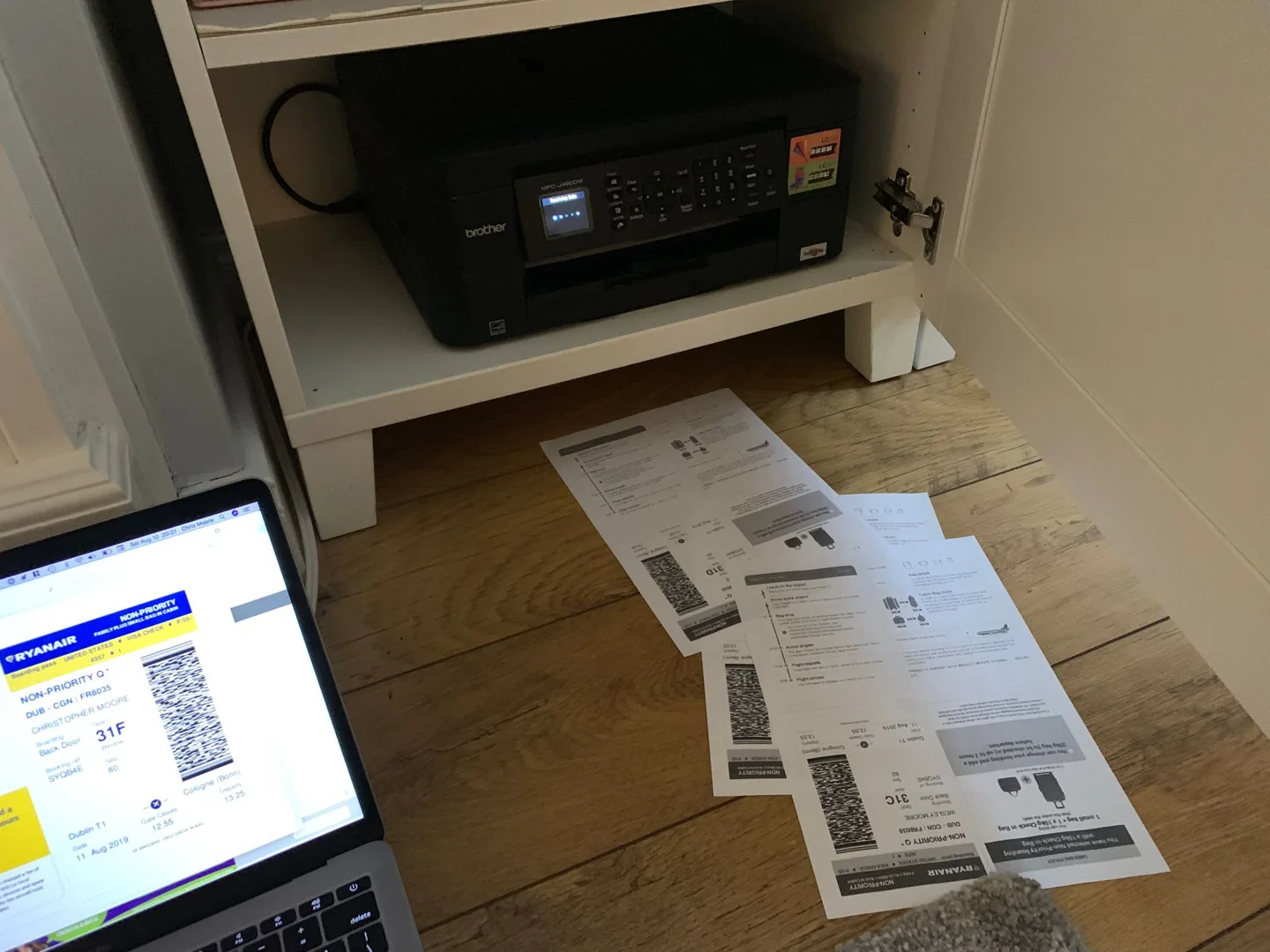 Laptop, printer, and boarding passes on a table