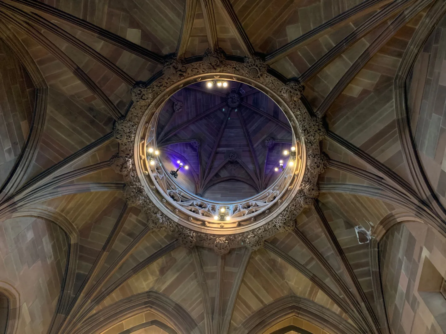 Circular stained-glass window in a vaulted ceiling