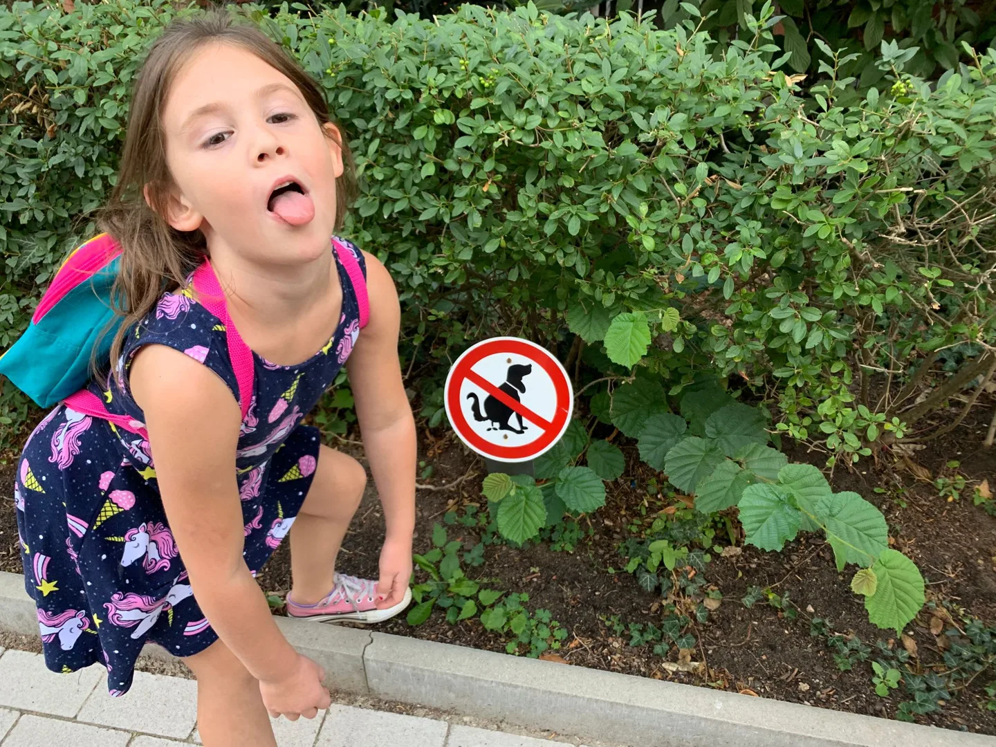 Child beside a garden sign