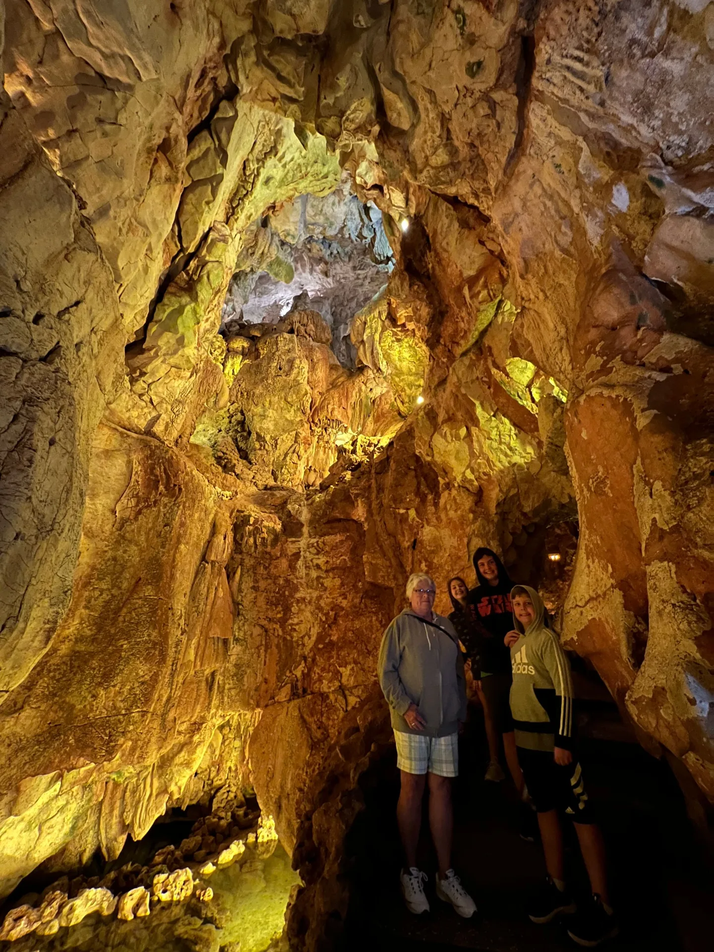 Visitors beside illuminated cave formations