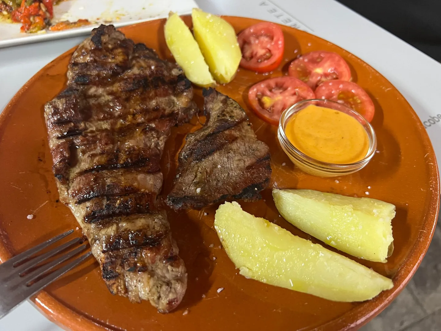 Grilled meat with potatoes and sliced tomatoes