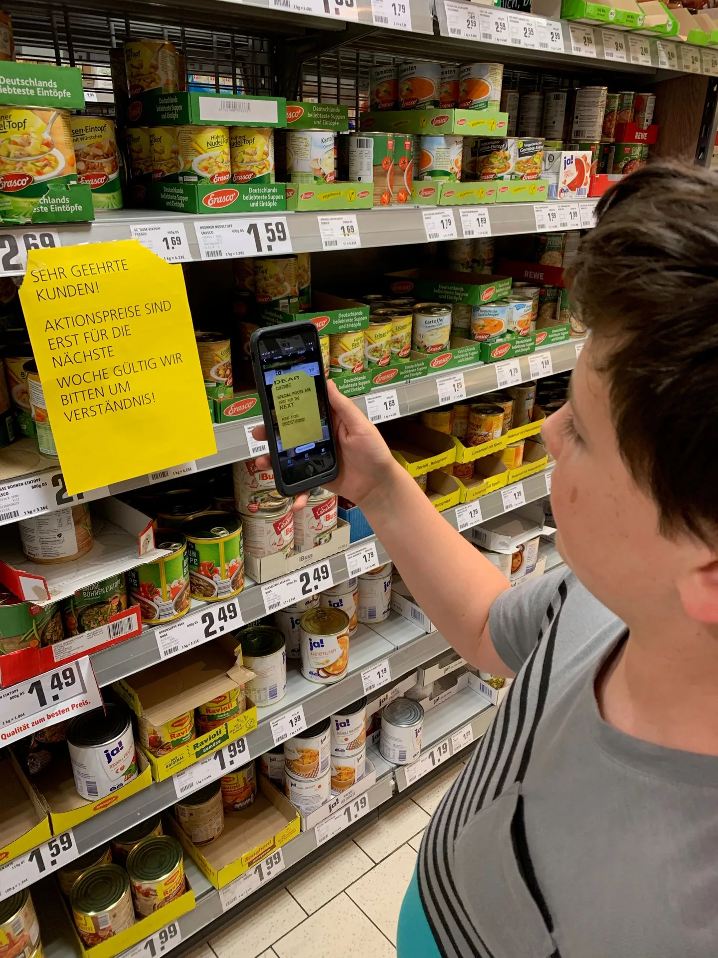 Child browsing jars on a grocery-store shelf