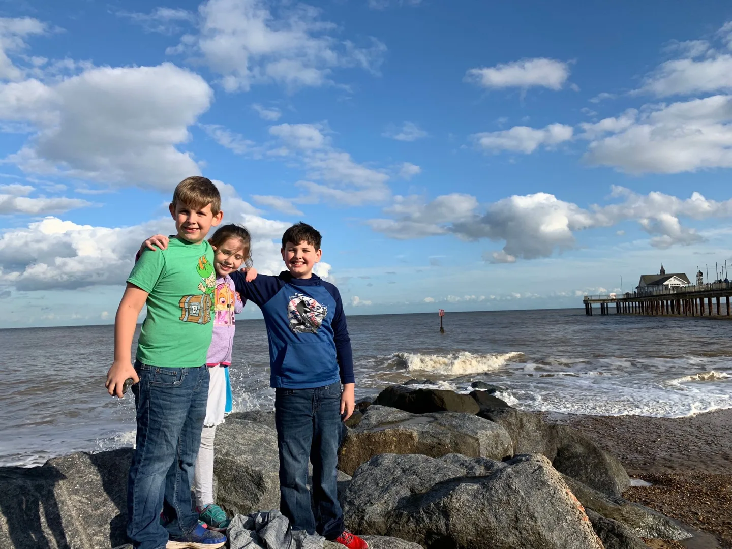 Children posing on rocks beside the sea
