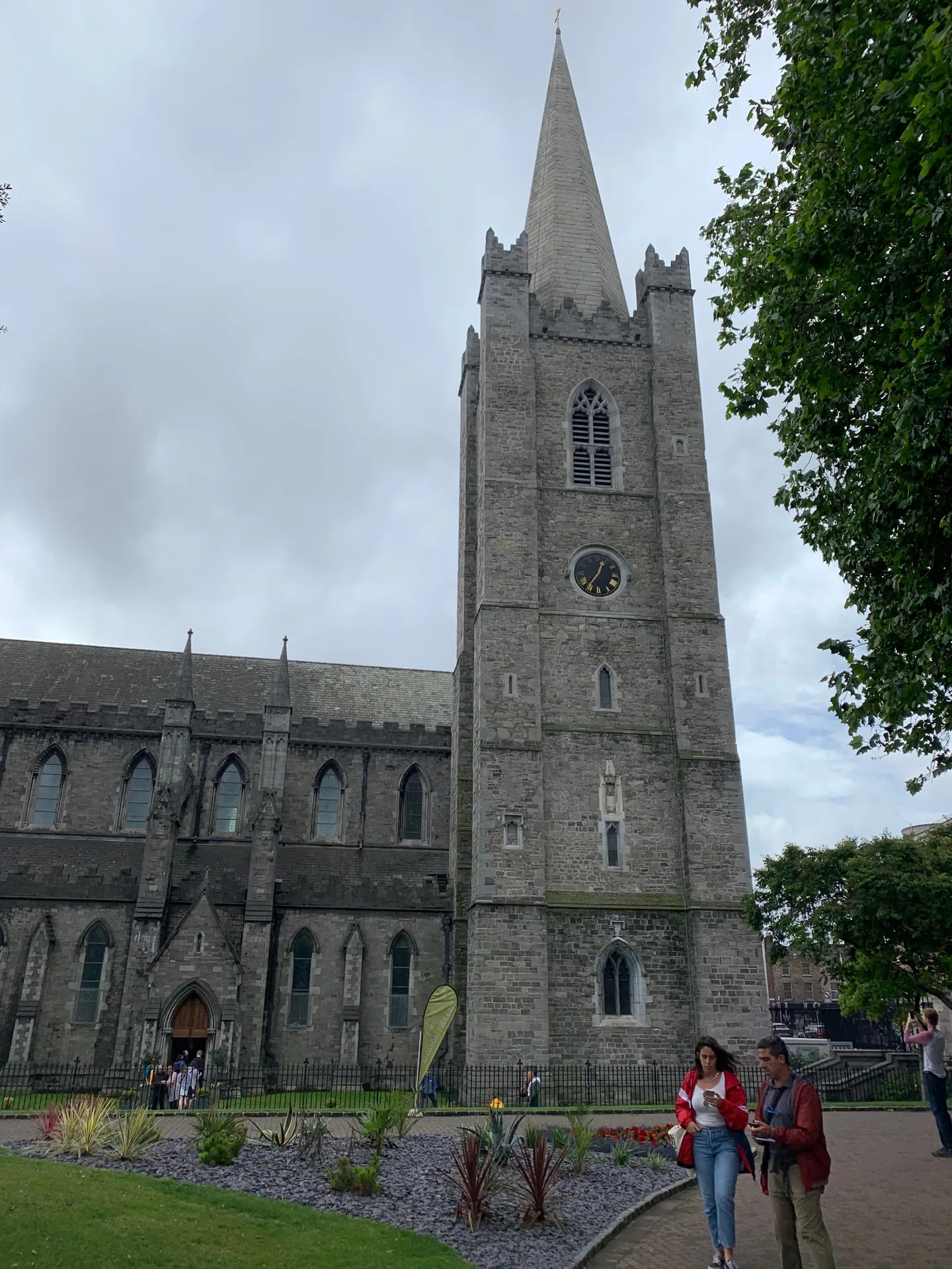 Tall cathedral spire beside a green lawn