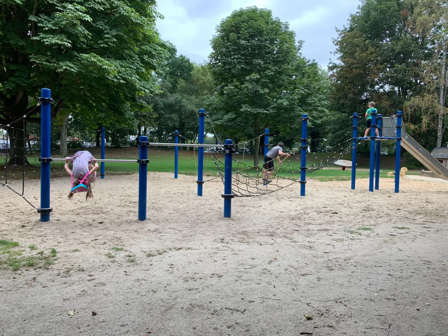 Children playing on blue playground equipment