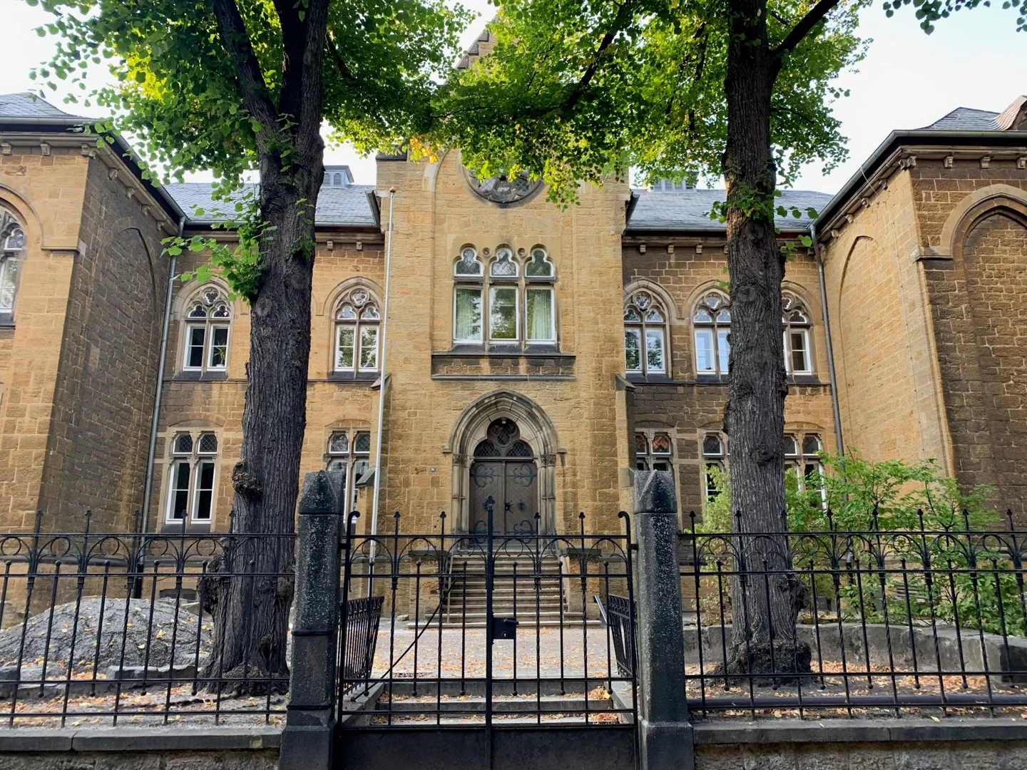 Historic stone building behind an iron fence