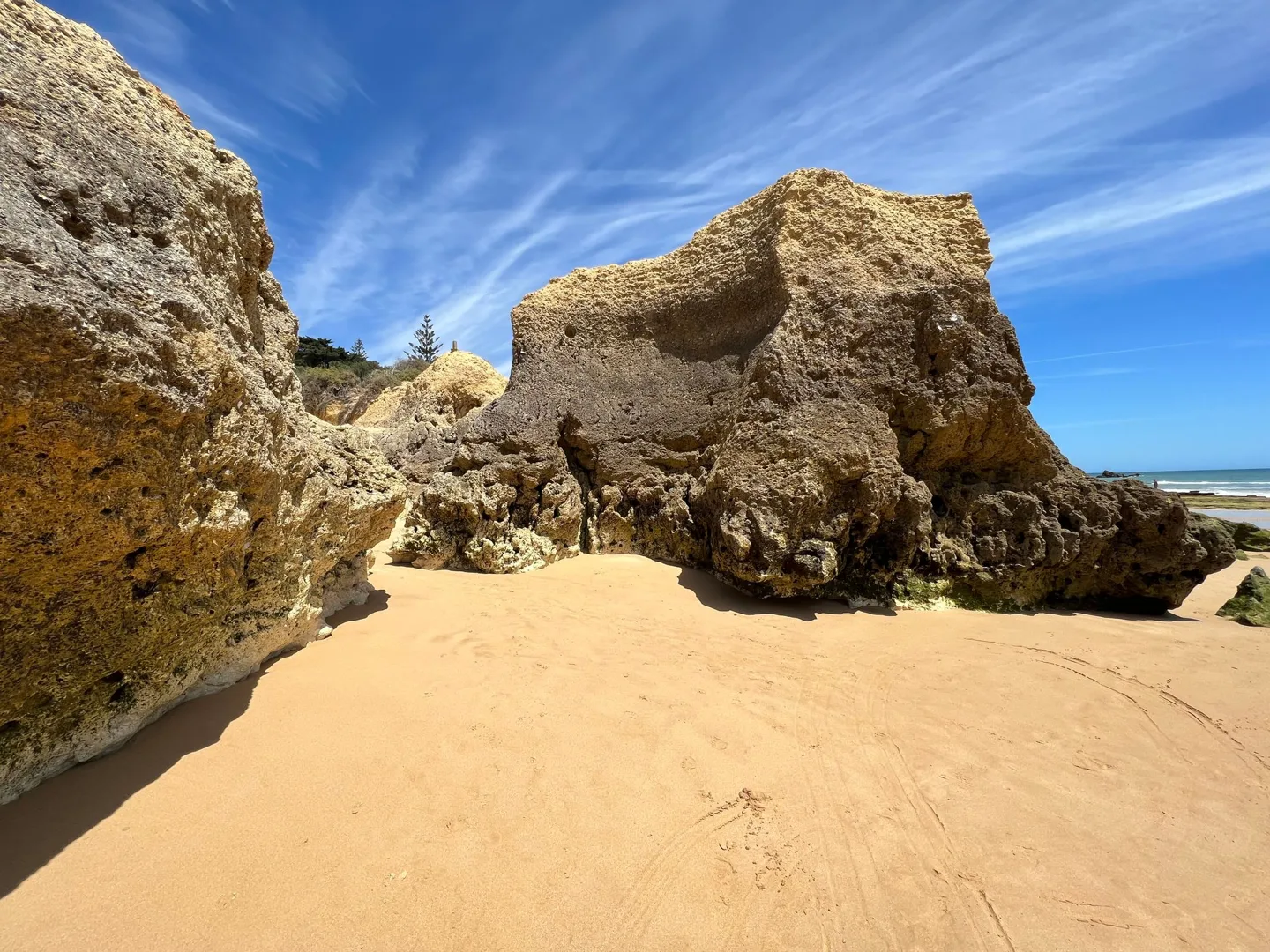 Sandy passage between coastal rock formations