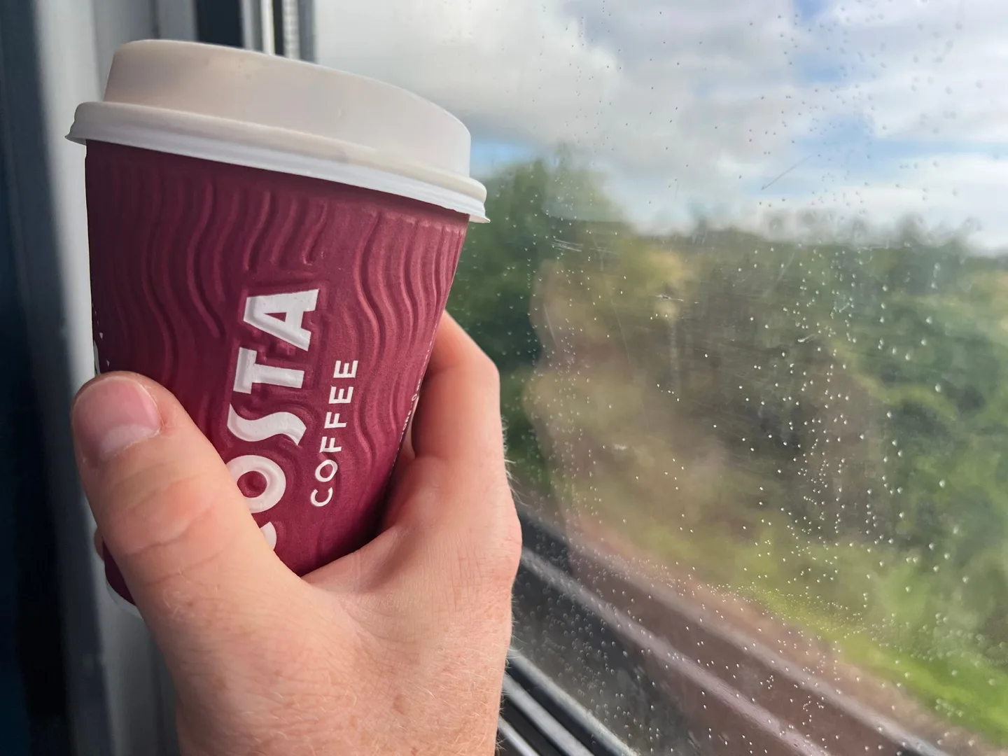 Costa coffee cup beside a train window