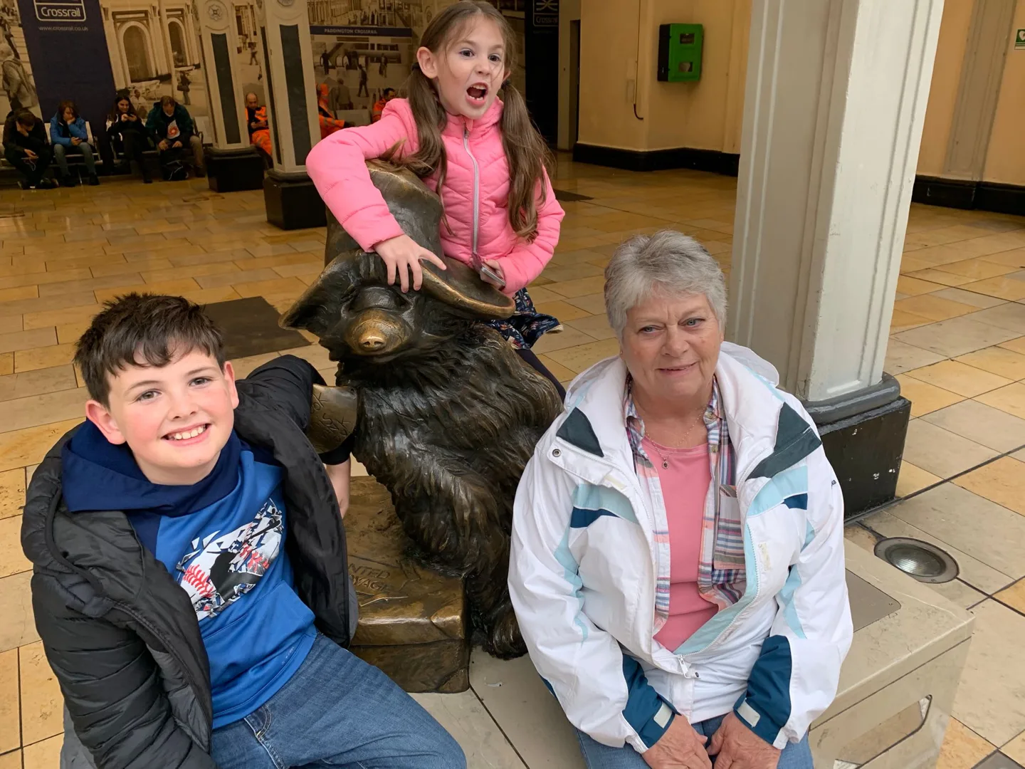 Family gathered around a bear statue