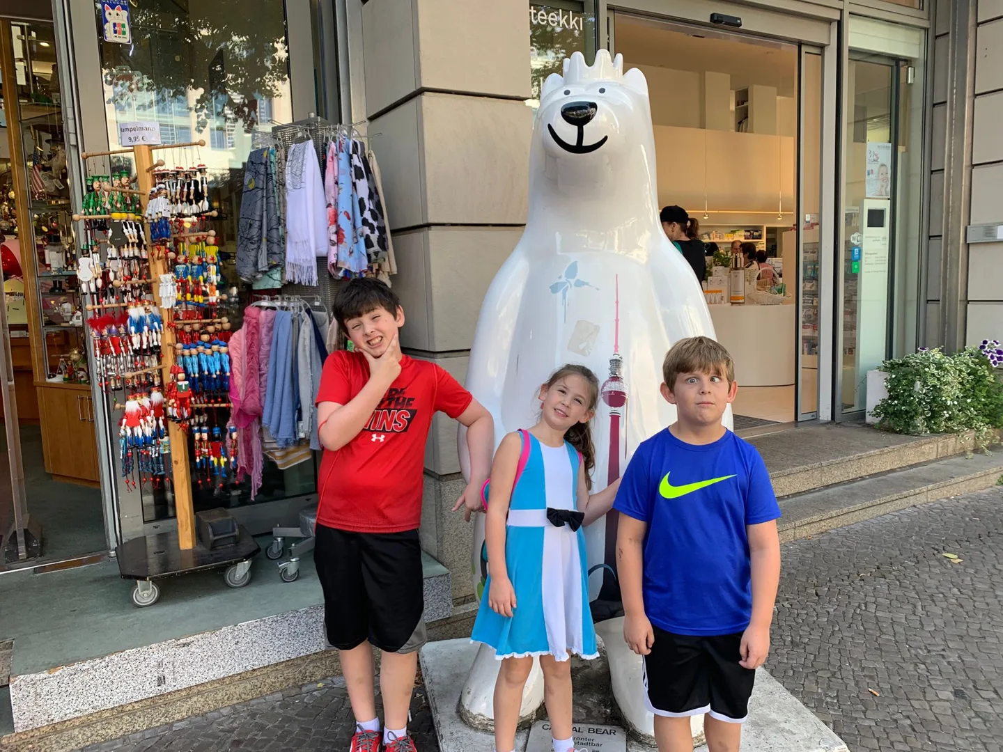 Children outside a shop with a white bear statue