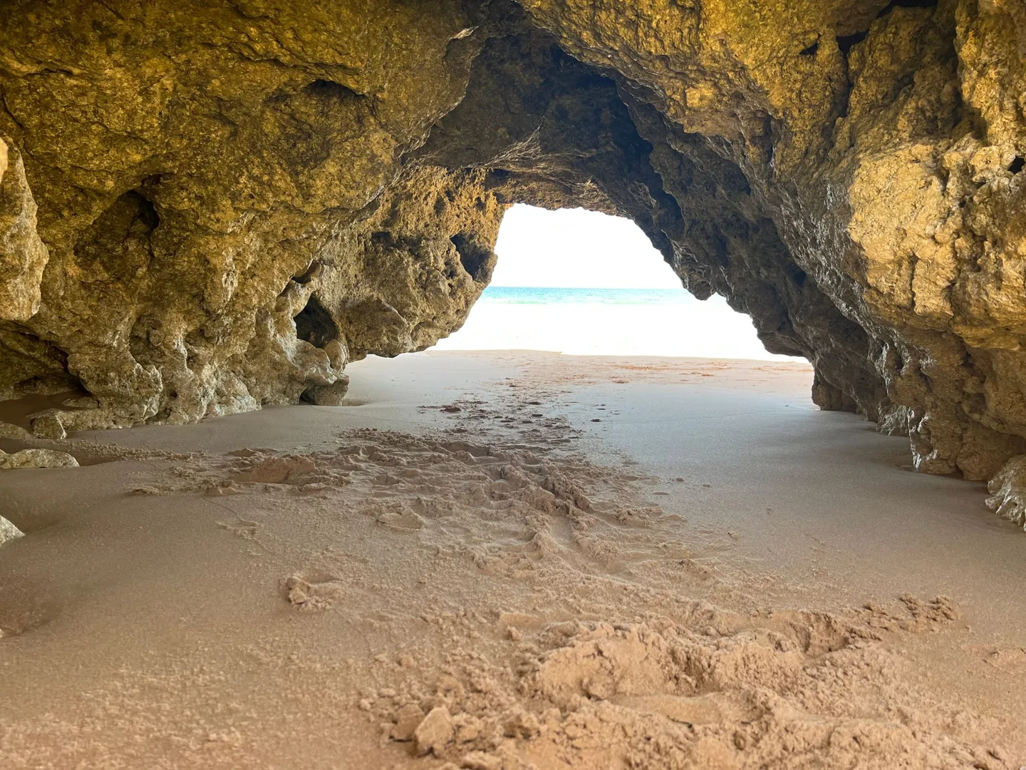View of the beach through a sea cave