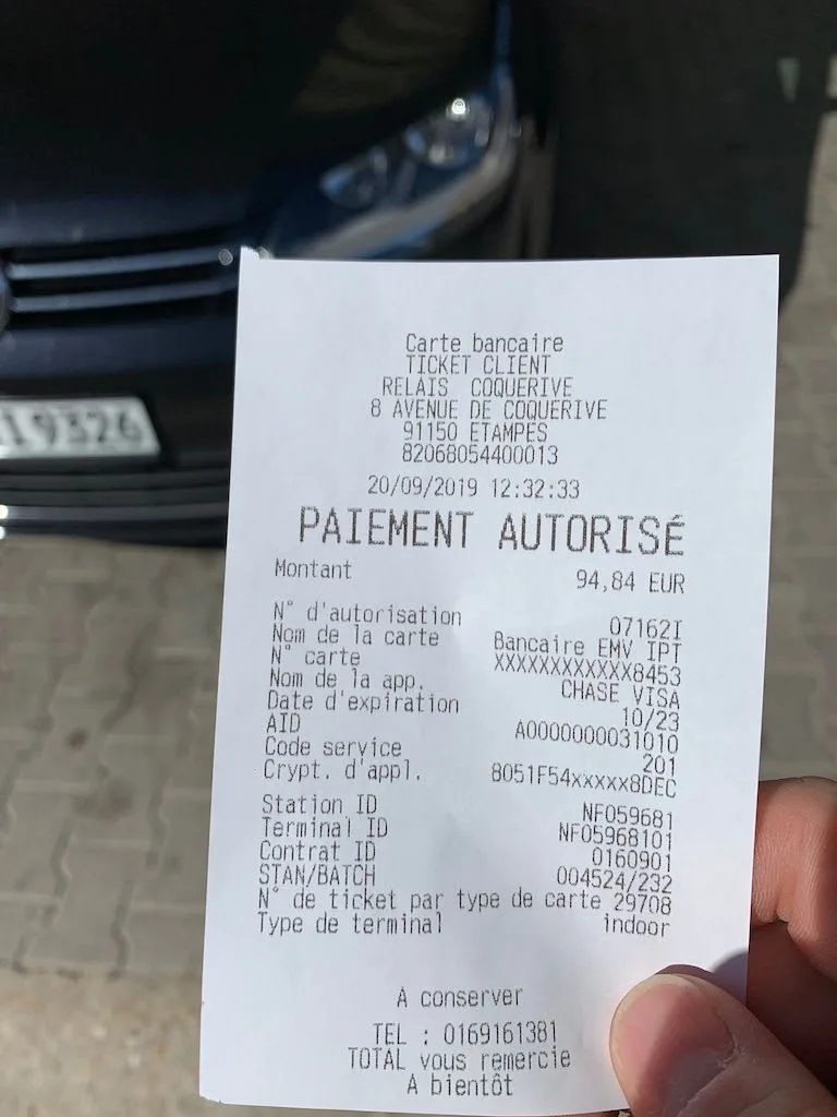Receipt held in front of a car dashboard