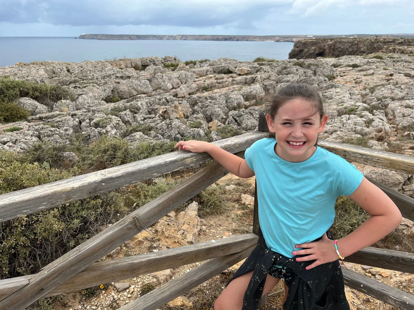 Child beside a wooden railing on the cliffs