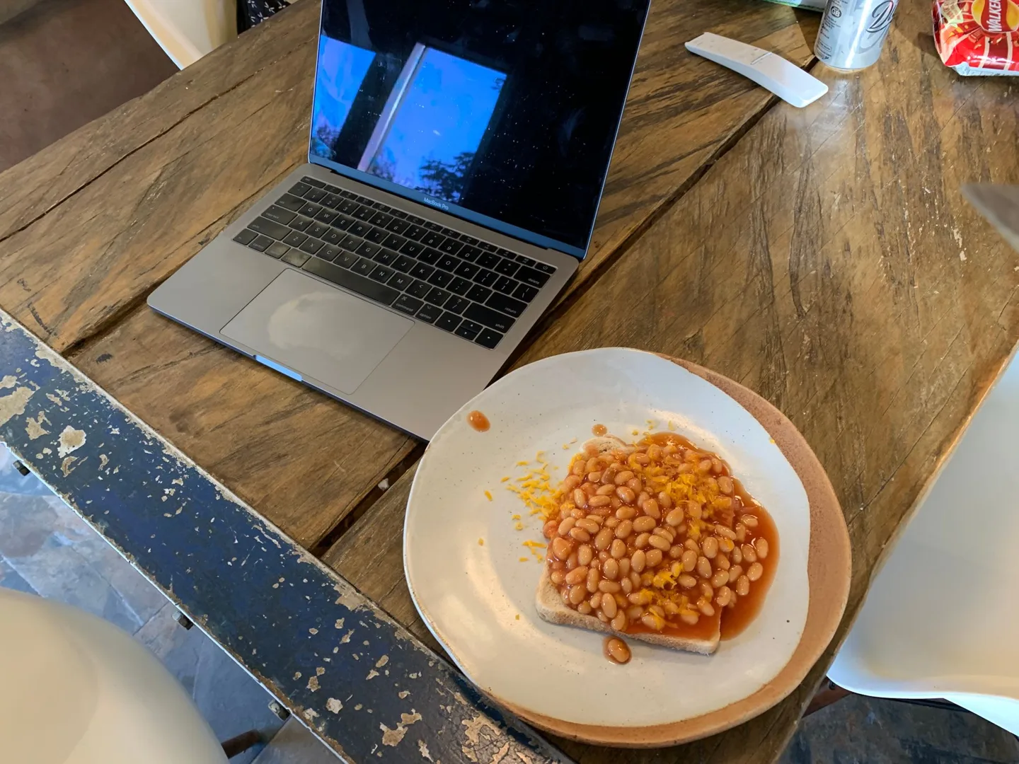 Laptop and plate of beans on toast