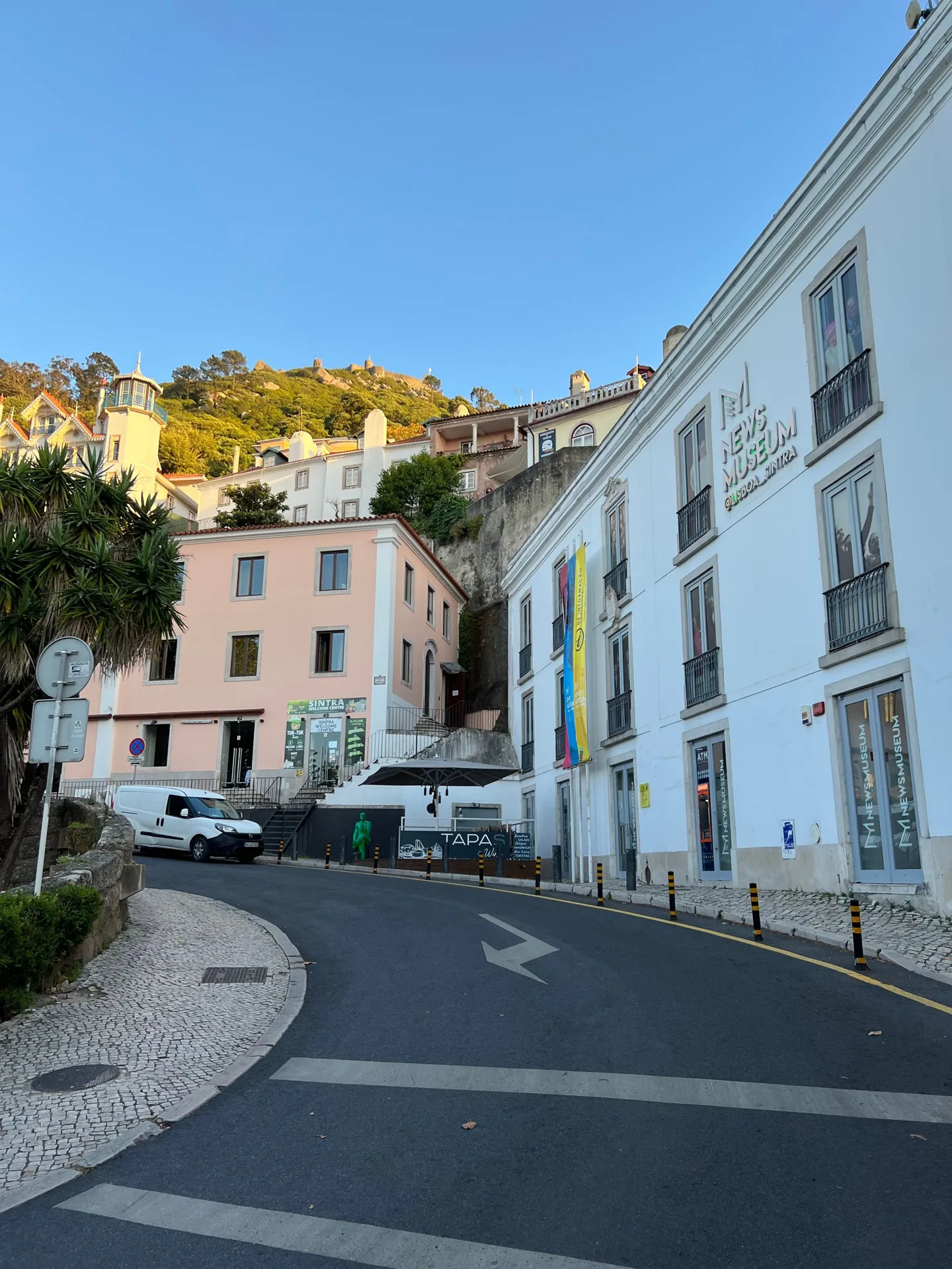 Curving road between white buildings