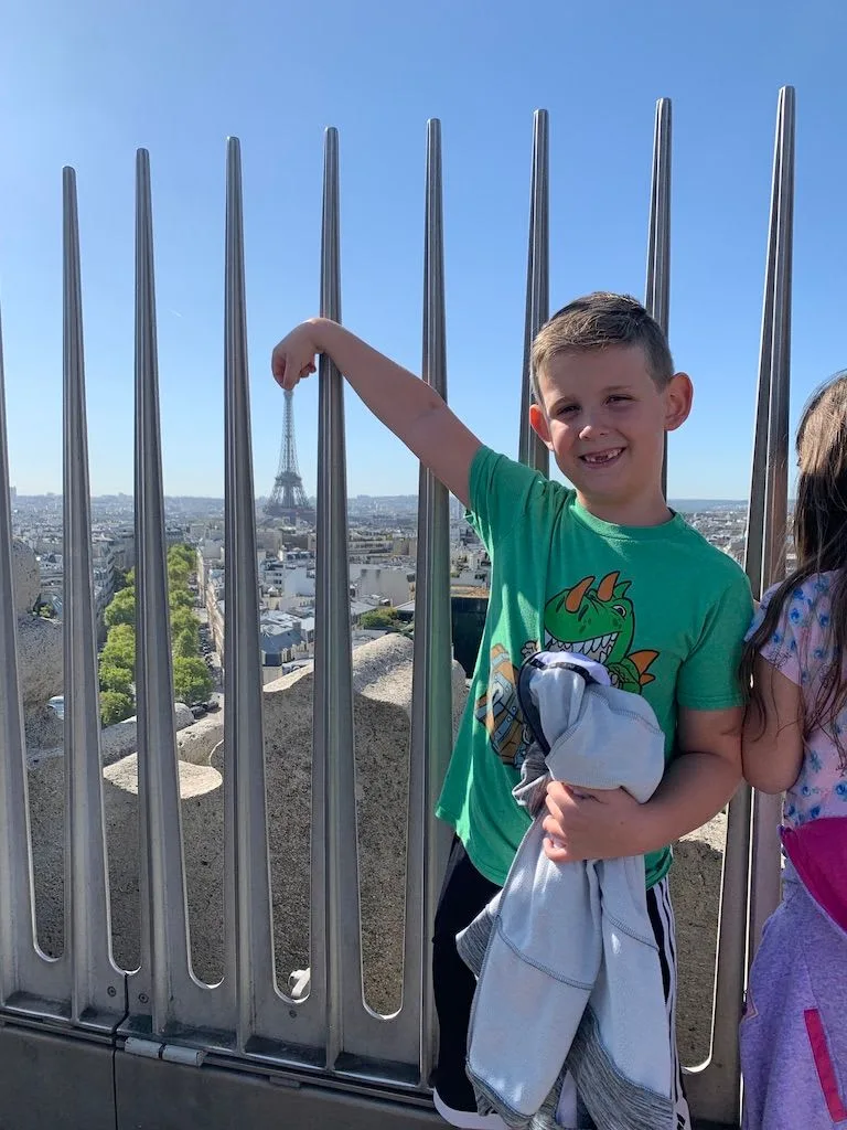 Child pointing from a rooftop lookout