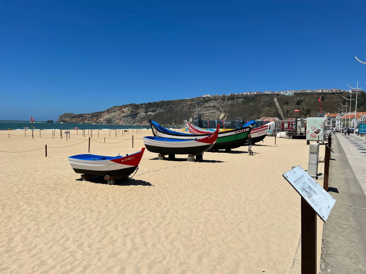 Painted fishing boats displayed on the sand